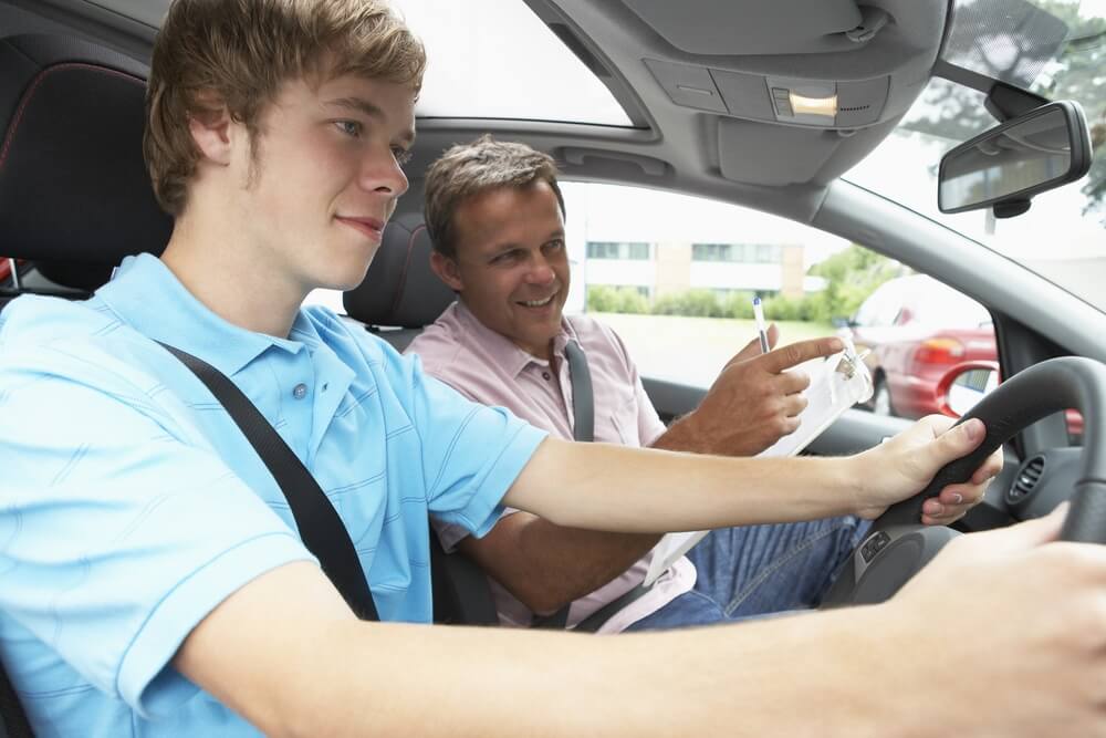 Older man teaching young man to drive