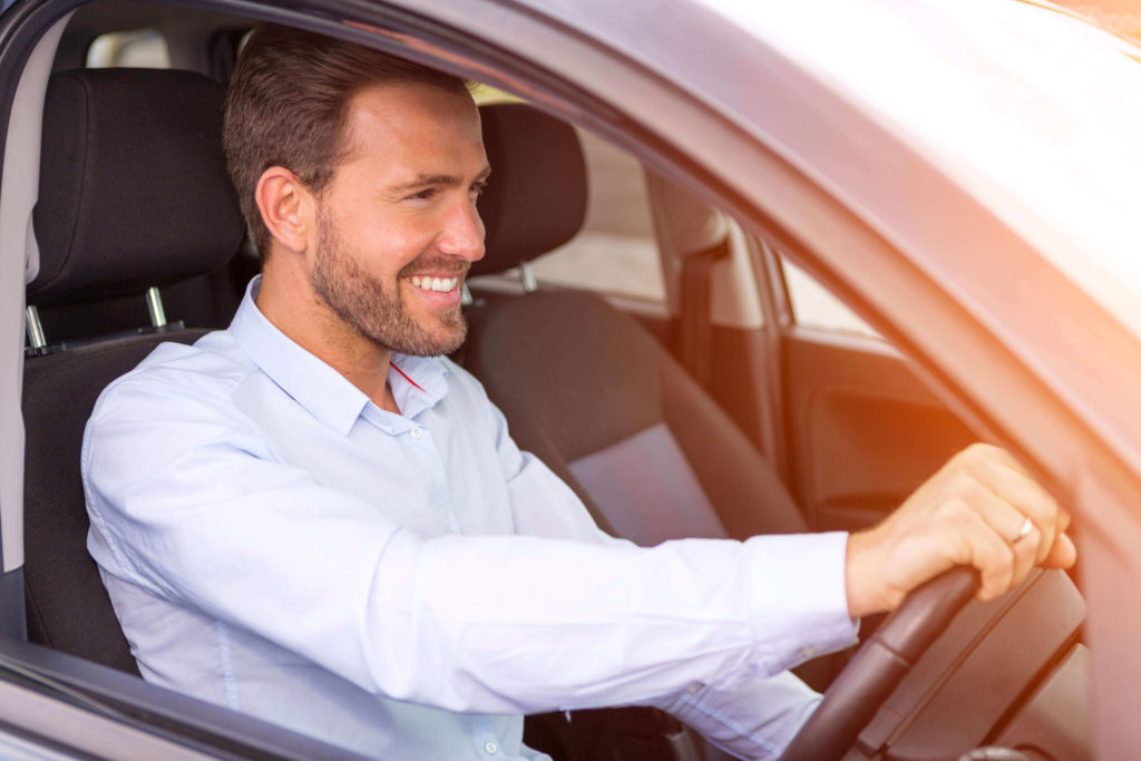 Man driving a car and smiling