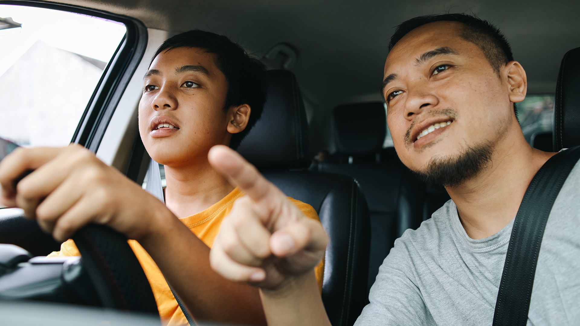 Father teaching his son how to drive