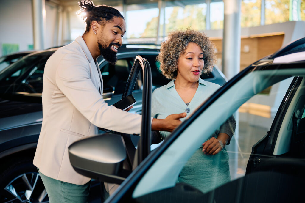 A salesperson detailing a used car