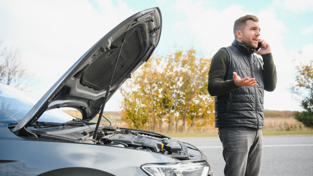 Man standing beside a broken-down car