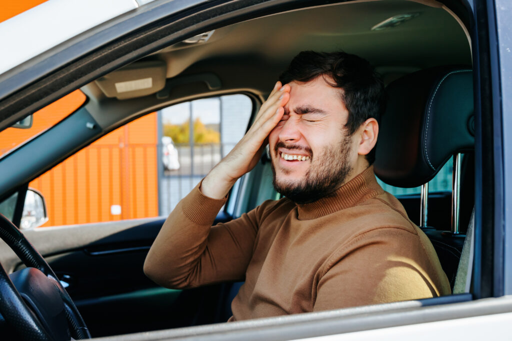 Bearded man driving and feeling ill